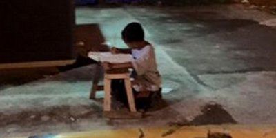 ON JE INSPIRIRAO SVIJET: Maleni beskućnik piše zadaću na cesti uz svjetlo iz restorana